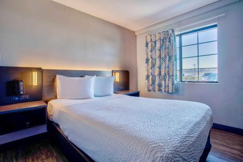 a hotel room with a large bed and a window at Motel 6-Kingman, AZ - Route 66 East in Kingman