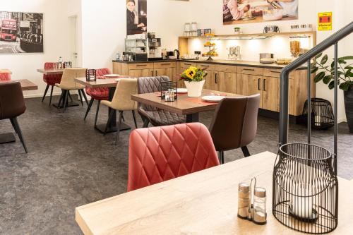 un restaurante con mesas y sillas y una cocina en Motel Hasetal en Löningen