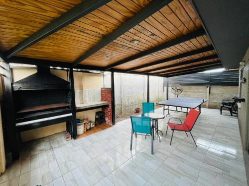 eine Terrasse mit einem Tisch, Stühlen und einem Klavier in der Unterkunft Casa Aislada Peñaflor-Malloco in Santiago