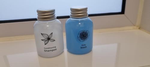 two bottles sitting on a counter in a bathroom at Check Inn Hotel in Cape Town