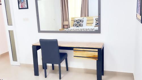 een bureau met een stoel en een spiegel bij Villa 3 Chambres Salon Adidogomé in Fazao