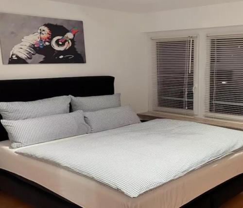 a bedroom with a bed with white sheets and a window at Departamento con dos habitaciones in Santiago