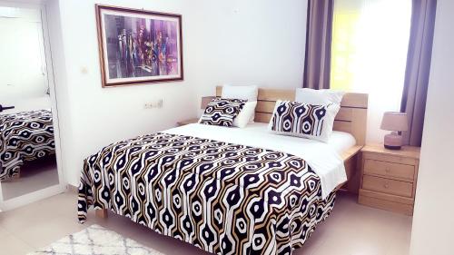een slaapkamer met een bed met een zwart-wit dekbed bij Villa 3 Chambres Salon Adidogomé in Fazao