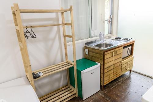 a small kitchen with a ladder next to a sink at Praia Camburi - Studios Kuta in Camburi
