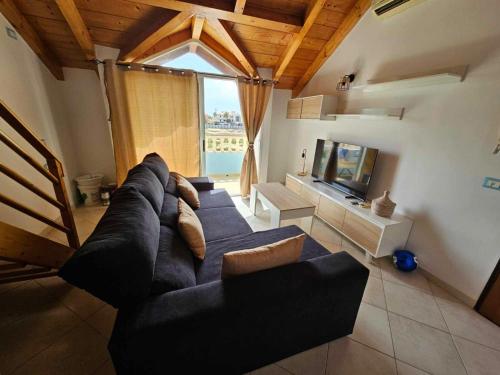 a living room with a couch and a television at Soleil Beach House in Santa Maria