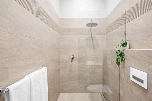 a bathroom with a shower with a glass door at THE OSLO on Broadway Villa 2 in Glenelg