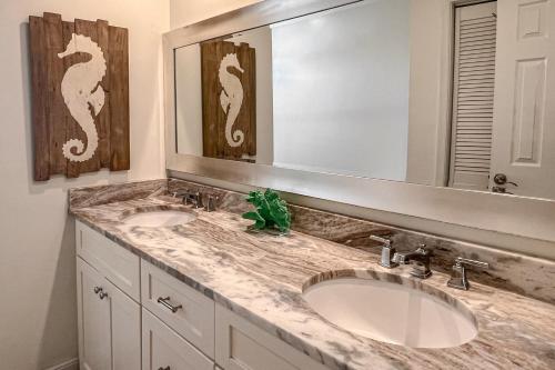a bathroom with two sinks and a large mirror at Sea La Vie in Virginia Beach
