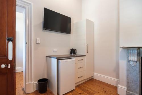 a kitchen with a refrigerator and a tv on the wall at Barossa Brauhaus Hotel in Angaston
