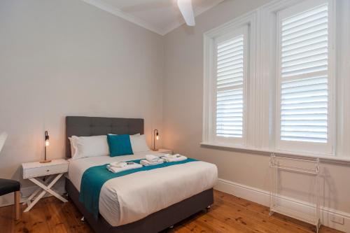 a bedroom with a bed and two windows at Barossa Brauhaus Hotel in Angaston