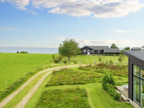 uma casa num campo com uma estrada de terra em 8 person holiday home in Knebel em Knebel