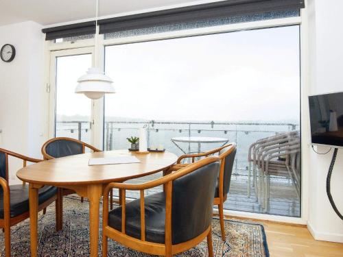 a dining room with a table and chairs and a large window at Holiday home Hejls XXIX in Hejls