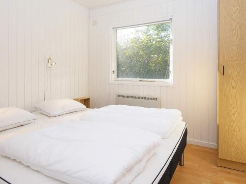 Holiday home Struer XII في Struer: سريرين في غرفة بيضاء مع نافذة
