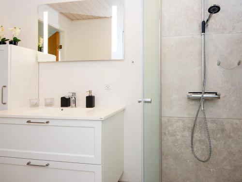 a white bathroom with a sink and a shower at Holiday home Struer XII in Struer