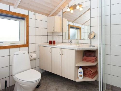 La salle de bains est pourvue de toilettes, d'un lavabo et d'un miroir. dans l'établissement Holiday home Lemvig XXVIII, à Lemvig