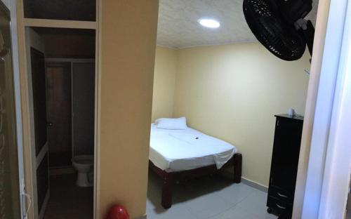 Dormitorio pequeño con cama y aseo en Hotel Indigo en Cartago