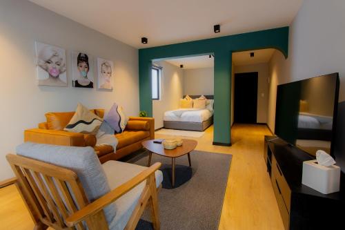 a living room with a couch and a bed at Capitalia Condesa Escandon in Mexico City
