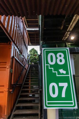 a green speed limit sign in front of a staircase at Praia Camburi - Studios Kuta in Camburi