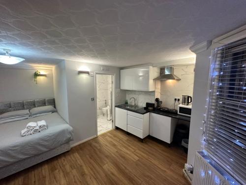 a small bedroom with a bed and a kitchen at Studio Room In Brighton in Brighton & Hove