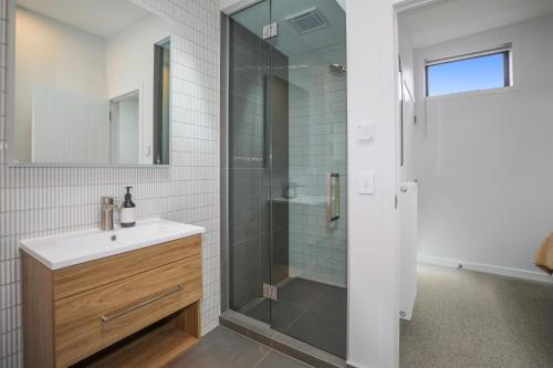 a bathroom with a glass shower and a sink at Inn Sophia in Rotorua