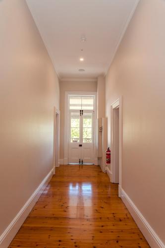 an empty hallway with a hard wood floor and a window at Barossa Brauhaus Hotel in Angaston