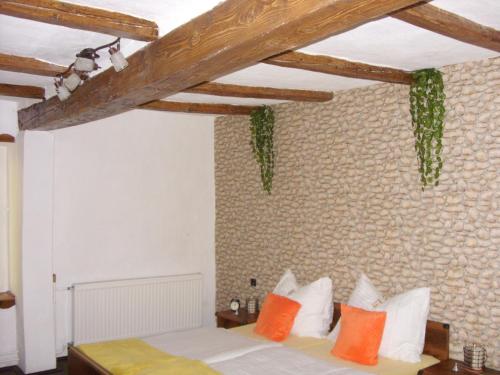 um quarto com uma cama com almofadas laranja e branca em Apartment Bodza em Tompa