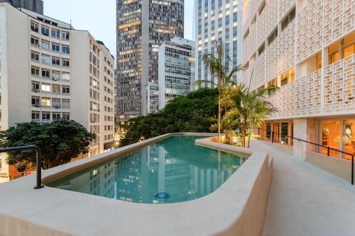 a swimming pool in the middle of a city with tall buildings at Tabas - Renata Edifício - Vila Buarque in Sao Paulo
