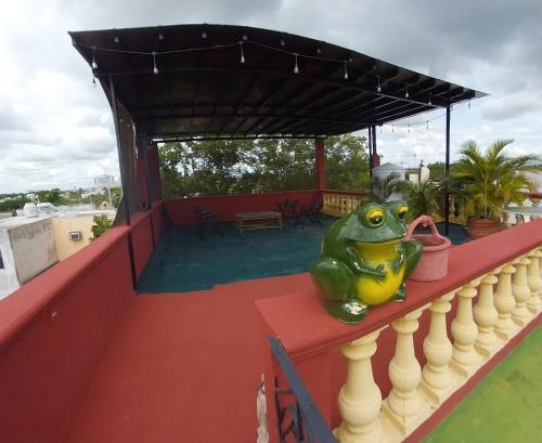 a toy frog sitting on the ledge of a roof at Hermosa casa cuatro recámaras independientes CA in Mérida