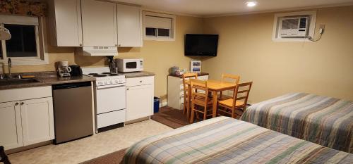 a small room with a kitchen with a bed and a table at Wilson Lake Inn in Wilton