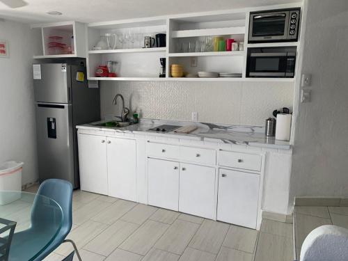 kuchnia z białymi szafkami i lodówką w obiekcie BEACHFRONT 14 Floor w mieście Puerto Vallarta
