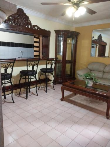 a living room with a couch and a table at Hermosa casa cuatro recámaras independientes CA in Mérida