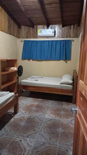 Pokój z łóżkiem i oknem z niebieską zasłoną w obiekcie Surf Shack Room #1 w mieście Pavones
