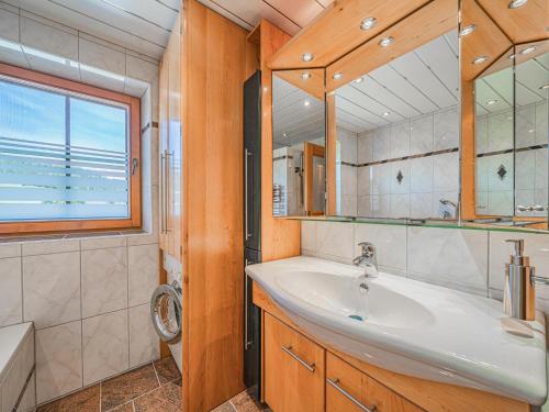 La salle de bains est pourvue d'un lavabo et d'un miroir. dans l'établissement Flicklhof XL, à Hopfgarten im Brixental