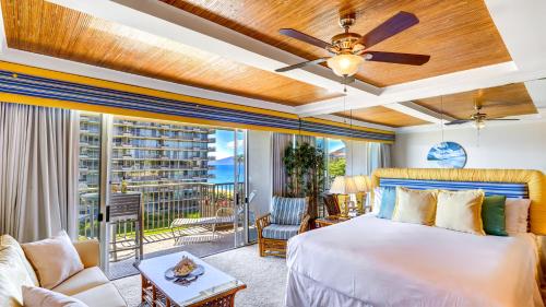 - une chambre avec un grand lit et un balcon dans l'établissement The Whaler Resort: Suite 515~Studio with Stunning Center Courtyard & Ocean Views, à Lahaina
