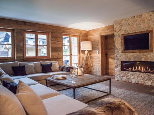 a living room with a couch and a fireplace at Kitz Boutique Chalet am Lift in Kirchberg in Tirol
