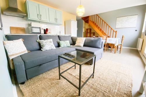 un salon avec un canapé bleu et une table dans l'établissement #GE - The Bostonian in Grenoble3 bedrooms with balcony, à Grenoble
