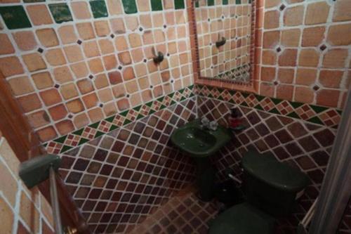 een badkamer met een groene wastafel en een toilet bij Mi casita “Chinco” estrellas in Zapatoca