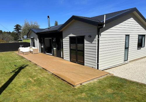 a house with a wooden deck in the yard at Naseby Modern Home in Naseby
