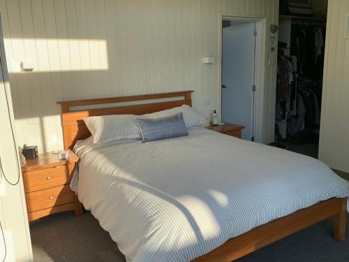um quarto com uma cama com uma almofada azul em The Admiral em Cooks Beach