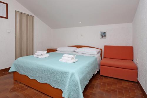 a bedroom with a bed and a red chair at Apartments with a parking space Kornic, Krk - 415 in Kornić