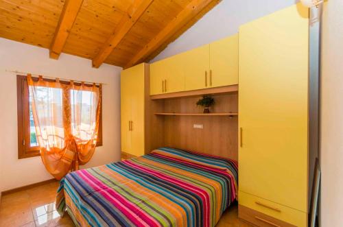 a bedroom with a bed with a colorful striped blanket at Holiday home in San Michele al Tagliamento 42857 in San Michele al Tagliamento