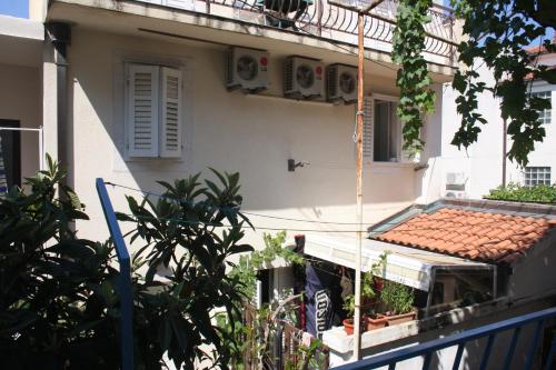 uma casa branca com uma varanda e um telhado em Apartment Andrijašević-CITY CENTER em Makarska