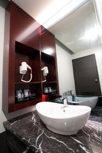 a bathroom with a large white sink on a marble counter at Pariss Hotel in Johor Bahru