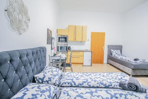 a living room with a couch and a kitchen at Comfort Quad room HN in Vienna