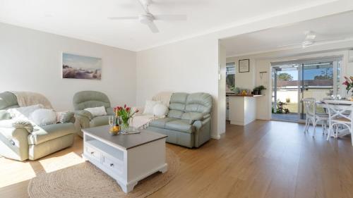 a living room with a couch and chairs and a table at Salty Marlin in Callala Bay