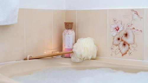 a bathroom with a bath tub with a bottle and flowers at Salty Marlin in Callala Bay