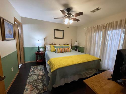 1 dormitorio con 1 cama y ventilador de techo en Cozy Comforts of Home, en Branson West