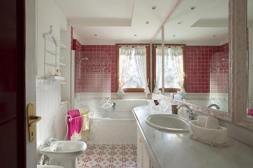 a bathroom with a sink and a tub and a toilet at Villa Gianturco - Luxury In The Green Island in Ischia