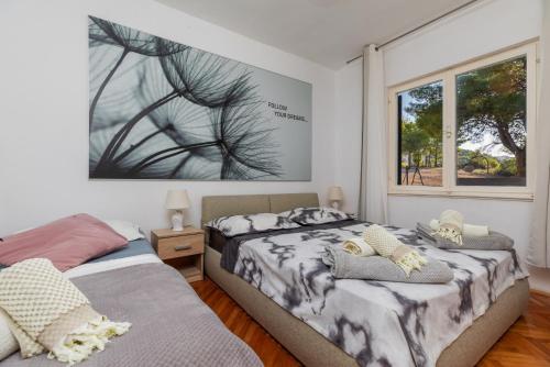 ein Schlafzimmer mit zwei Betten und einem Fenster in der Unterkunft Apartments by the sea Balica Rat, Omis - 1065 in Omiš