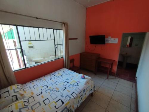 um quarto com uma cama, uma janela e um lavatório em LAS ORQUIDEAS Hospedaje em Pucallpa