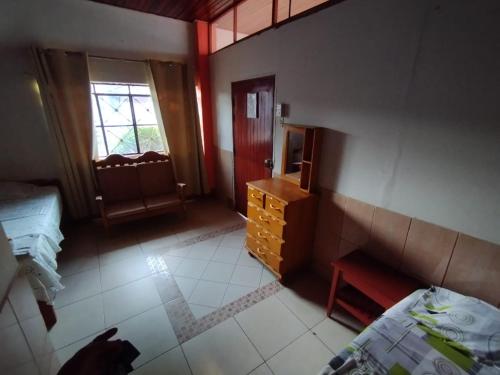 Zimmer mit einem Schlafzimmer mit einem Bett und einer Kommode in der Unterkunft LAS ORQUIDEAS Hospedaje in Pucallpa